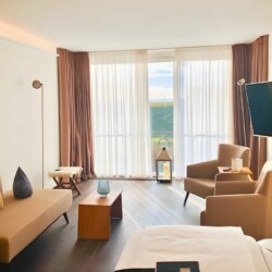 Apartment Juistblick 1 – Heller Wohnbereich mit Panoramafenstern und gemütlicher Sitzecke für möbliertes Wohnen auf Zeit