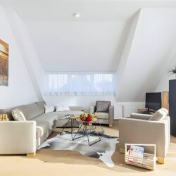 Apartment Schwalbennest Penthouse – Helles Wohnzimmer mit moderner Einrichtung und Sitzbereich