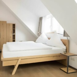 Apartment Schwalbennest Penthouse – Modernes Schlafzimmer mit Dachfenster und geräumigem Kleiderschrank