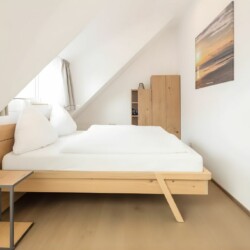Apartment Schwalbennest Penthouse – Schlafzimmer mit Doppelbett und Tageslicht unter Dachschräge